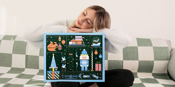 Femme heureuse avec le calendrier de l'Avent fitness 2023 nu3