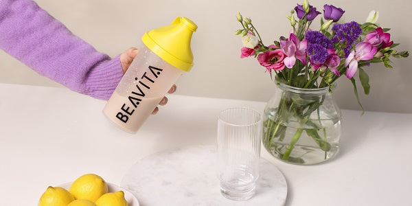 BEAVITA Slim Shaker avec verre et fleurs sur la table