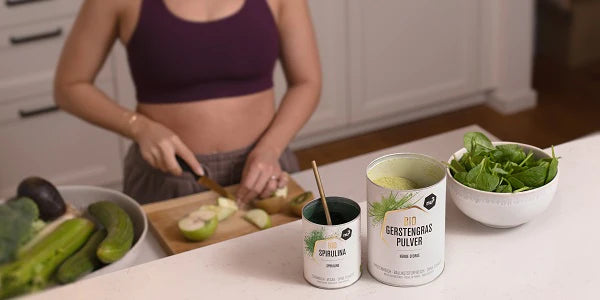 Femme coupant des pommes avec spiruline bio nu3 sur la table