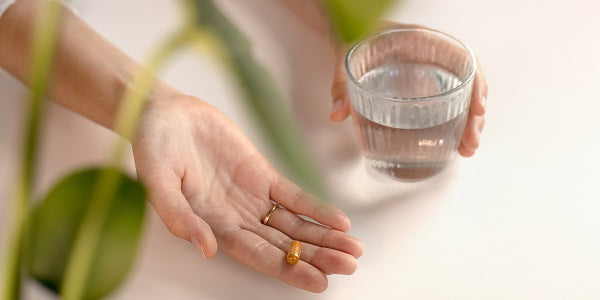 Gélules de curcuma bio nu3 avec un verre d'eau