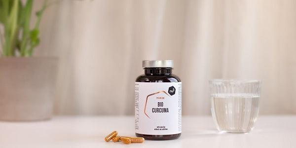 Boîte de Curcuma bio Premium nu3 et un verre d'eau