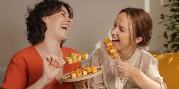 2 femmes mangeant des brochettes de tofu