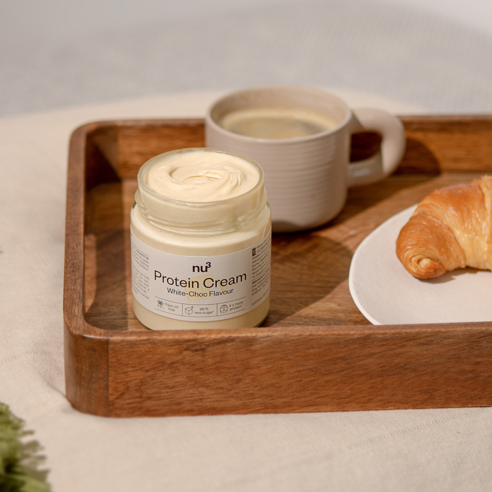 Plateau petit-déjeuner avec café, croissant et un verre de nu3 Protein Cream White-Choc