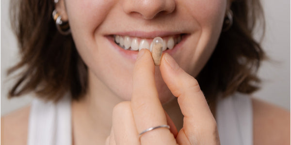 Gélule devant la bouche d'une femme