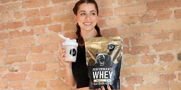 Femme qui tient un shake et un paquet de whey nu3