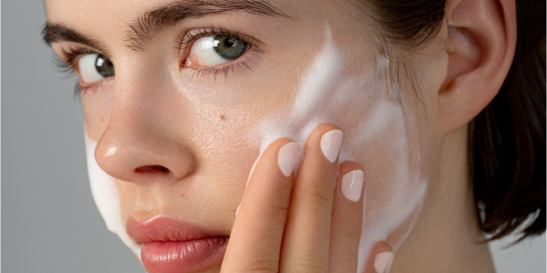 Femme avec mousse nettoyante douce pour le visage