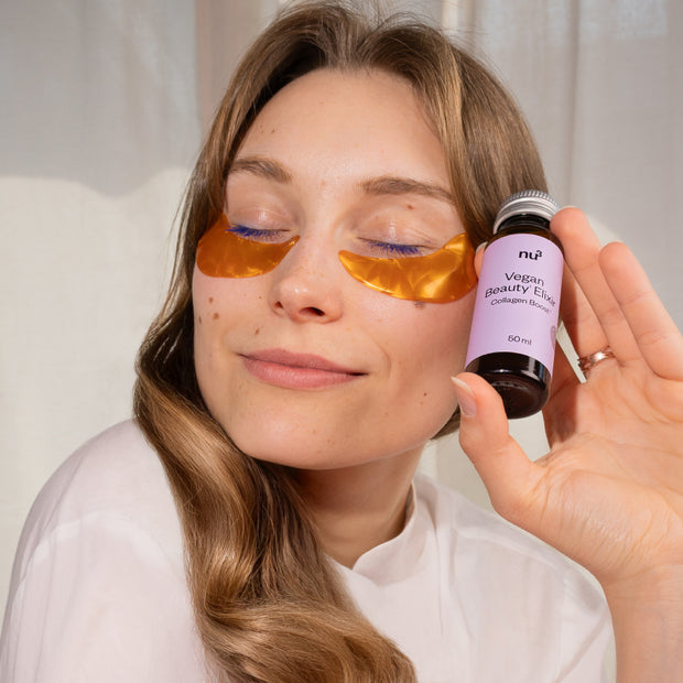 Femme aux yeux fermés tenant une petite bouteille dans sa main