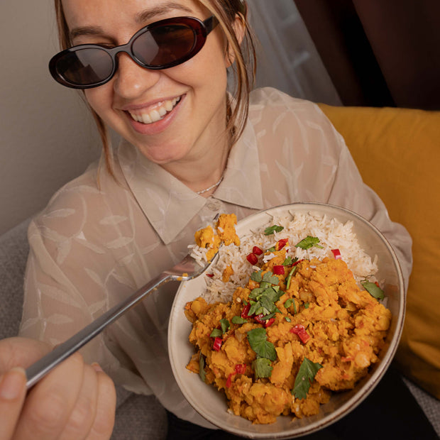 Femme avec un bol de curry aux lentilles jaunes