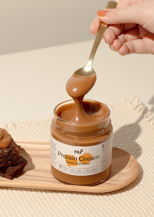 nu3 Protein Cream Salted Caramel sur une petite planche en bois avec une cuillère