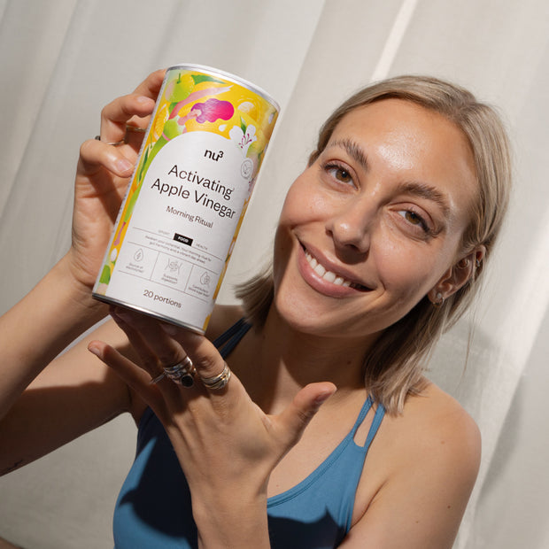 Femme avec une boîte de nu3 Activating¹ Apple Vinegar