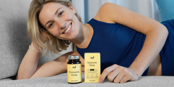 Jeune femme en haut bleu allongée sur le canapé avec le nu3 Curcuma Forte