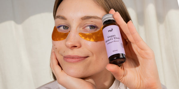 Femme tenant un flacon de Vegan Beauty Elixir à la main